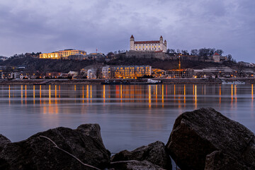 Obraz premium Bratislava Castle at dusk above the Danube with city lights in Slovakia