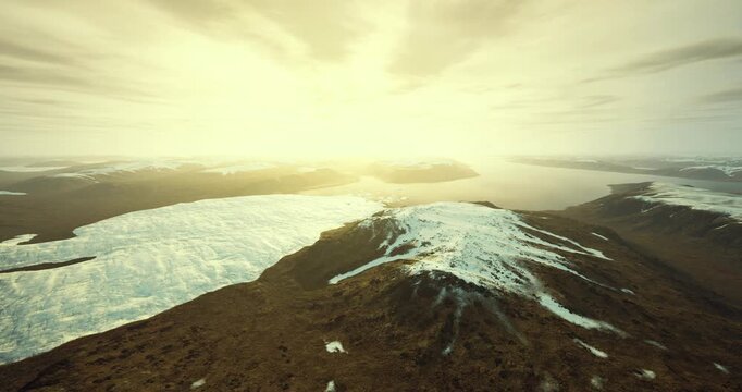 Snowy ridge overlooking glacial expanse and ocean, scientific perspective highlights melt patterns, sediment lines and coastline change for field research