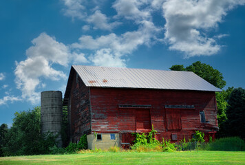 Obraz premium Cracked and Peeling Paint Clings to Red Wooden Barn