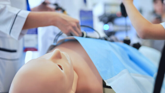 Medical students practicing laparoscopic surgery on a manikin during training simulation