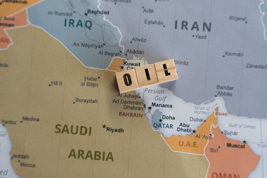 Wooden letter blocks spelling OIL placed on a map of the Middle East, specifically over the Persian Gulf region, symbolizing global energy supply, OPEC production, and geopolitical stability