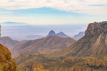 Expansive view of layered desert mountains and distant peaks in Big Bend National Park, Texas. The rugged terrain and soft atmospheric haze highlight the vast scale of the Chihuahuan Desert landscape. © ZL Visuals
