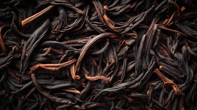 The image shows a close up view of dried, dark colored plant material, likely tea leaves or herbs