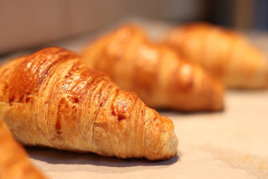 Croissant dor&eacute; frais sur papier cuisson, sortie du four