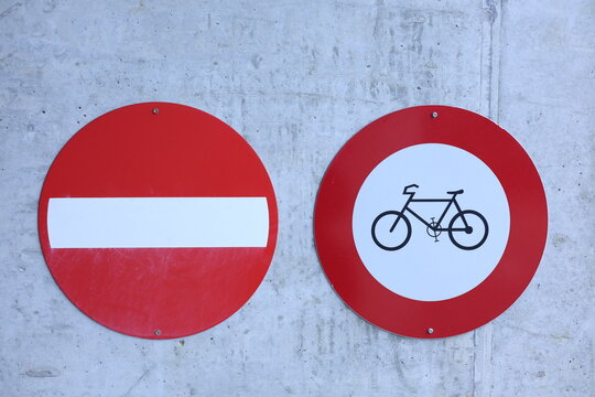 panneaux sens interdit et interdiction aux v&eacute;los sur mur gris