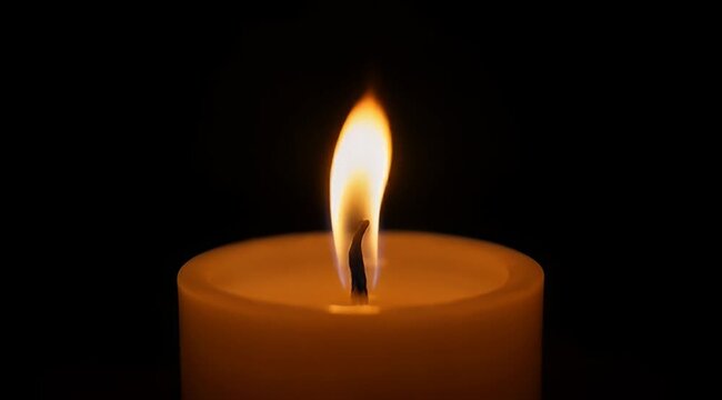 A warm and inviting close up shot of a flickering candle flame
