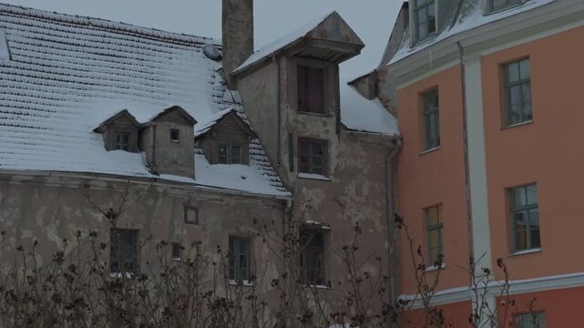 Snowcovered historic courtyard view. Snowdusted buildings with dormer windows and textured stone walls casting soft light