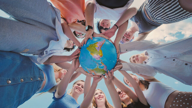 Students holding a globe and advocating for environmental protection and global collaboration towards a sustainable future