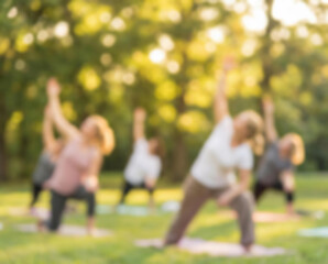 Obraz premium Women practicing yoga outdoors in a park at sunset