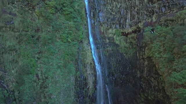 Detailed aerial shot of waterfall cascades in Madeira 25 Fontes, drone hovering near falling water and green tropical cliffs, Laurisilva forest, 4K.