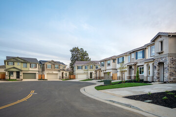 Obraz premium Modern New Construction Homes Along Curved Residential Street in Suburban Housing Development, Residential Real Estate Market, Planned Community, and Single Family Neighborhood Growth