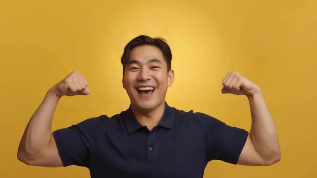 明るい黄色背景で日本人青年が紺のポロと大きいジーンズで喜ぶ