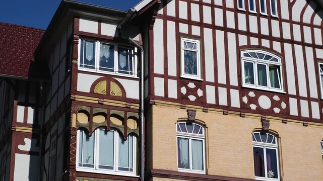 Half-timbered house in Meiningen, Thuringia - East Germany. Close-up slow motion of a traditional German building with detailed windows and facade. Tilt-down street view.