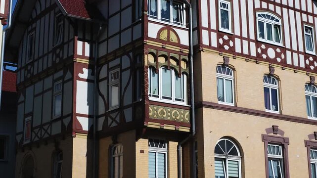 Half-timbered house in Meiningen, Thuringia - East Germany. Close-up slow motion of a traditional German building with detailed windows and facade. Tilt-up street view.