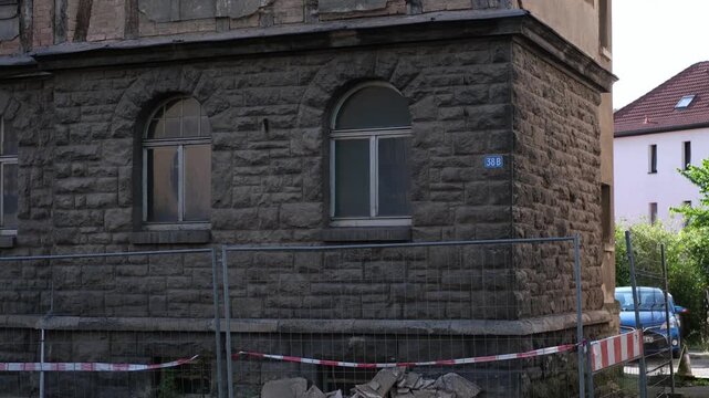 Half-timbered house with crumbling plaster in Meiningen, Thuringia - East Germany. Close-up slow motion building facade. Tilt-up street view of an old, not renovated traditional German house.