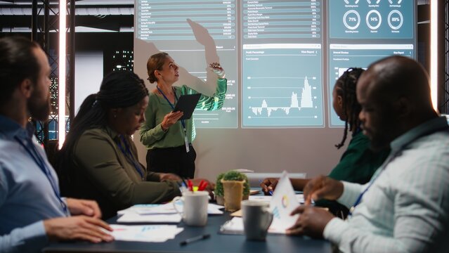Team of company analysts review feedback on data insights to work on future improvements, developing marketing and PR strategies in meeting room. Business enterprise coworkers. Camera A.