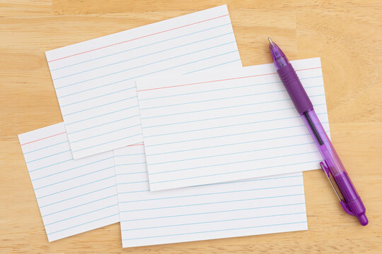 Scattered index cards with purple pen on desk