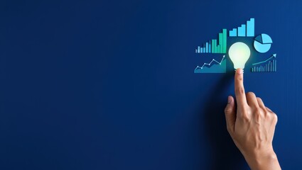 Fototapeta premium A hand touches a glowing lightbulb with graphs and charts floating above on a blue background.