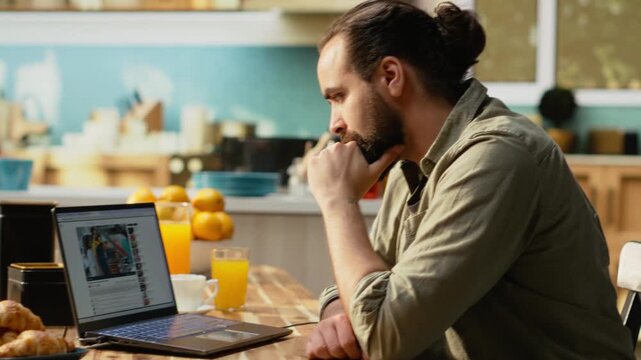 Adult man, online video content on laptop, streaming platform for digital clips, free to watch video supporting relaxed lifestyle moment at home. Enjoying online entertainment, everyday life.