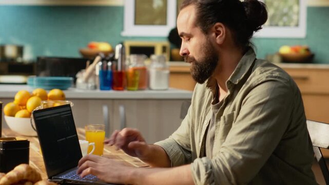 Adult man working remotely with reports and data analytics on laptop, software showcasing infographic elements and digital tools. Remote worker does daytime work for task management.