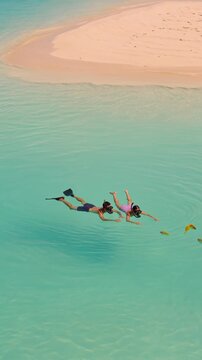 Couple snorkeling together in crystal clear tropical waters