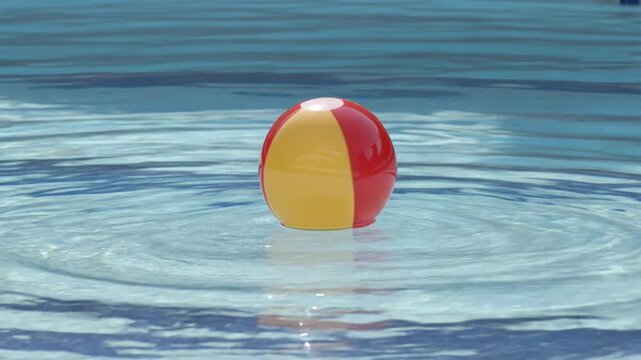 Colorful beach ball floating in swimming pool water