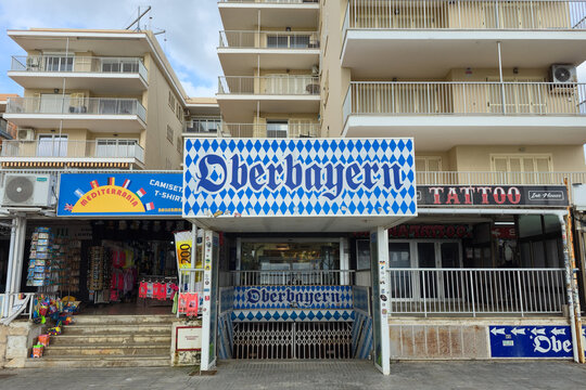 PALMA, SPAIN - MARCH 10, 2026: Entrance to the Oberbayern nightclub with its blue and white Bavarian diamond pattern sign, located on the beachfront of Platja de Palma, Mallorca.