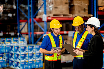 Professional logistics team planning distribution operations in modern storehouse. Diverse workers and manager checking commercial packages for safe freight delivery. © ultramansk