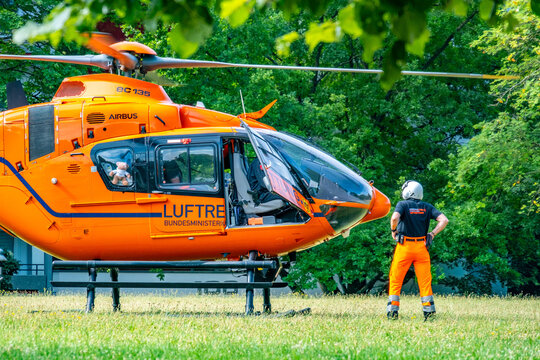 Pilot in uniform standing by Emergency rescue helicopter EC135, German medical Luftrettung ready emergency mission, urban background, public service, landing zone, Frankfurt, Germany - July 5, 2025