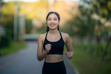 Fototapeta premium Woman running in park smiling enjoying healthy lifestyle