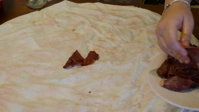 Placing Pastirma Slices on Thin Dough for Savory Pastry