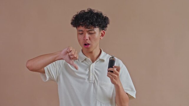 Asian male rejecting e-cigarette use with thumbs down sign