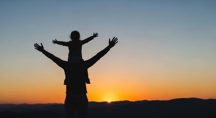 Fototapeta premium Father and child silhouette with arms raised celebrating on mountain top at sunset