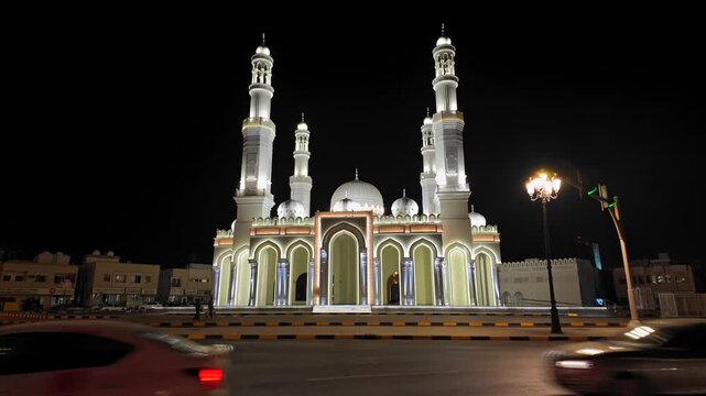A view of a beautifully illuminated mosque at night in Sharjah, United Arab Emirates.