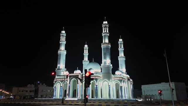 A view of a beautifully illuminated mosque at night in Sharjah, United Arab Emirates.