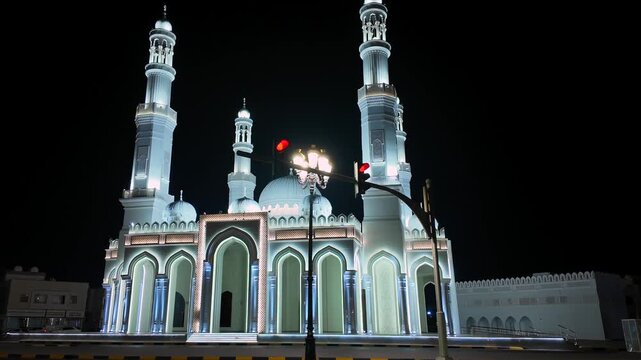 A view of a beautifully illuminated mosque at night in Sharjah, United Arab Emirates.