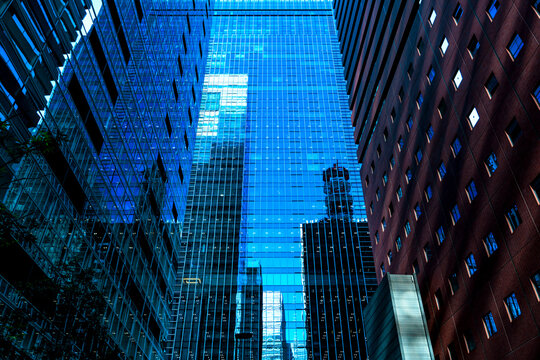 Modern glass skyscrapers with architectural reflections in Tokyo business district.