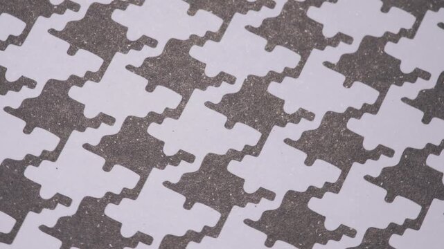 Dynamic rotating pied-de-poule pattern on grainy paper for fashion concepts, Rotating classic houndstooth background with grey shapes on white textured surface