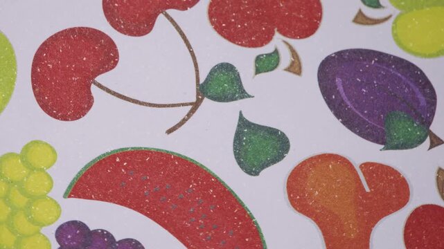 Close up pan of colorful mixed fruit pattern on white paper, Artistic smooth rotation over textured paper with healthy fruit design