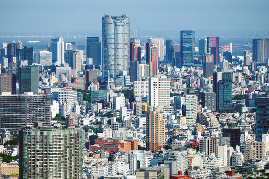 Mori Tower at Roppongi Hills and the Tokyo Bay skyline with Rainbow Bridge, Minato, Tokyo, Japan.