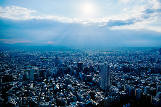 Dramatic sunbeams and crepuscular rays over the vast cityscape of Tokyo, Japan.