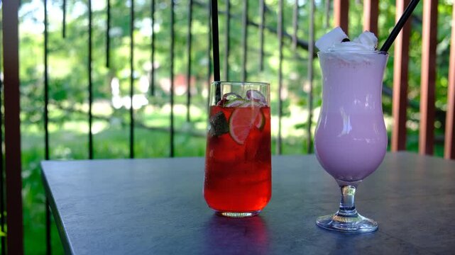 Summer red cocktail with mint and lime and berry milkshake, drinks glass aperitif at outdoor garden party. Countryside, patio