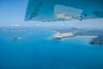 Airplane wing flying over whitehaven beach whitsunday islands