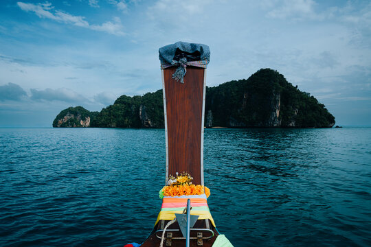 Long-tail boat advancing on andaman sea towards tropical island