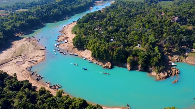 A scenic drone view of the Lalakhal Sari-Goain River in Jaintapur, Sylhet, from above the clear blue sky, which is known as a famous tourist destination in Bangladesh for its clear blue waters.