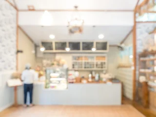 Fotobehang Horeca Blurred cafe and bakery interior background with warm lighting and clean modern design, creating soft bokeh atmosphere ideal for coffee shop promotion, lifestyle branding, and cozy workspace concept.  © tete_escape