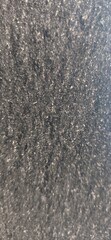Abstract dark asphalt texture background with gritty granular surface and radial blur effect. Industrial stone pattern for modern web design and urban backdrop.