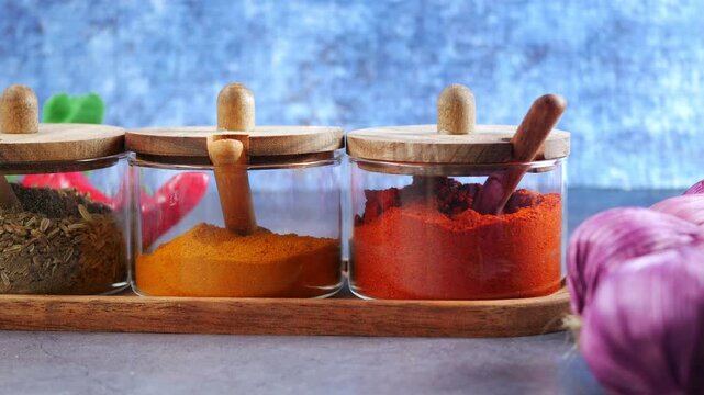 Spices in jars with purple onions on a table