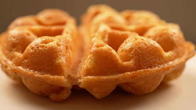 Macro shot of golden brown hong kong bubble waffle (gai daan jai) surface texture, detailed close-up of delicious asian street food snack.