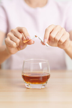 woman hand break and stop gesture to refuse cigarette and glass of Whisky, for say no to alcohol drink and for World No Tobacco Day, quitting smoking to prevent Lung Cancer and stop nicotine addiction